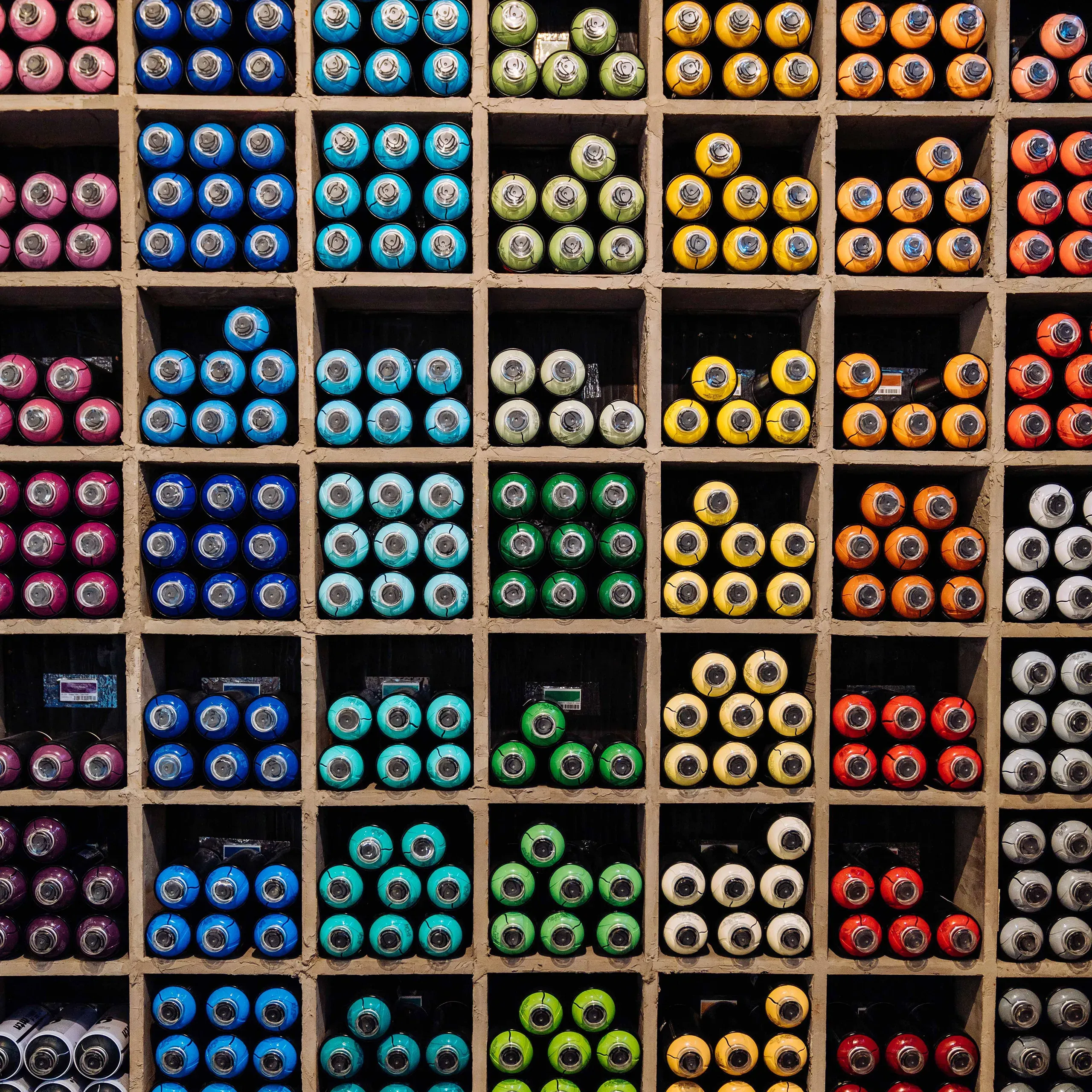 Organized rows of paint color tubes stored neatly in small compartments, giving a sense of order and creativity