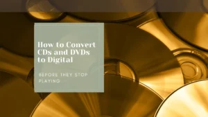 Stack of shiny CDs and DVDs with text overlay reading How to Convert CDs and DVDs to Digital, Before They Stop Playing